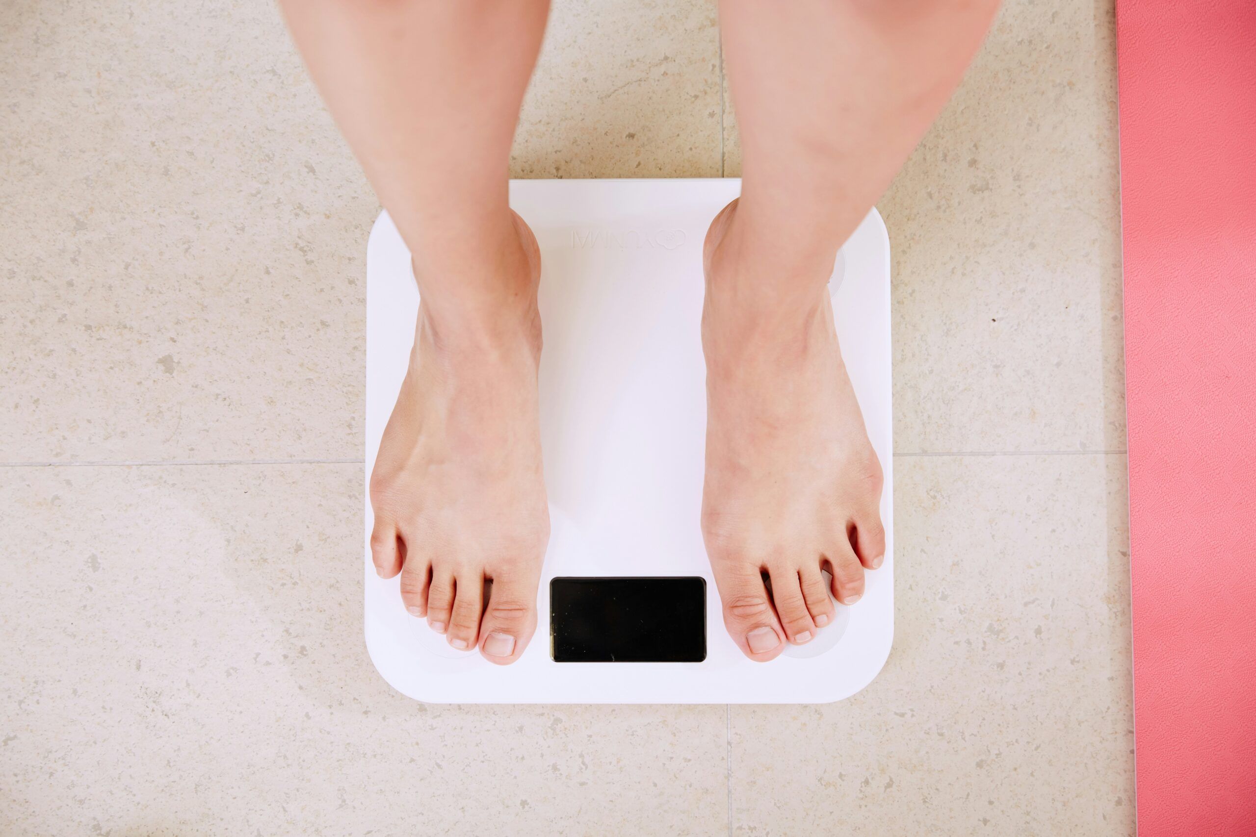 Patient check-in scene for medically guided weight-loss program, clinician reviewing progress and adjusting GLP-1 therapy (semaglutide or tirzepatide) with patient.